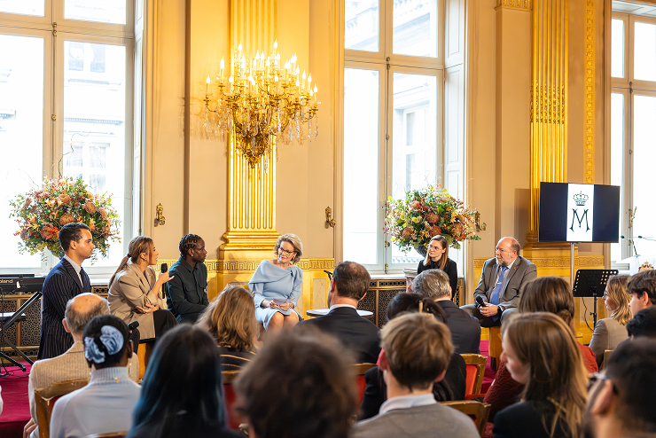 Discussion avec un panel et face à une audience dans un salon royal.